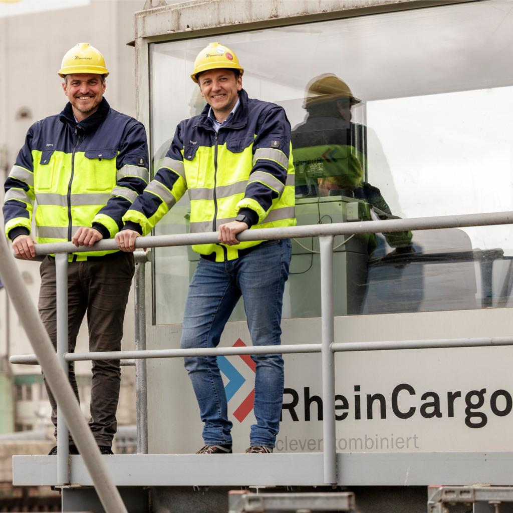 Foto zweier Mitarbeiter der RheinCargo in Signalwesten und Schutzhelm