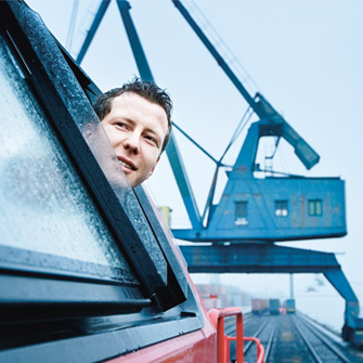 Ein Triebfahrzeugführer schaut aus dem Fenster einer Lok