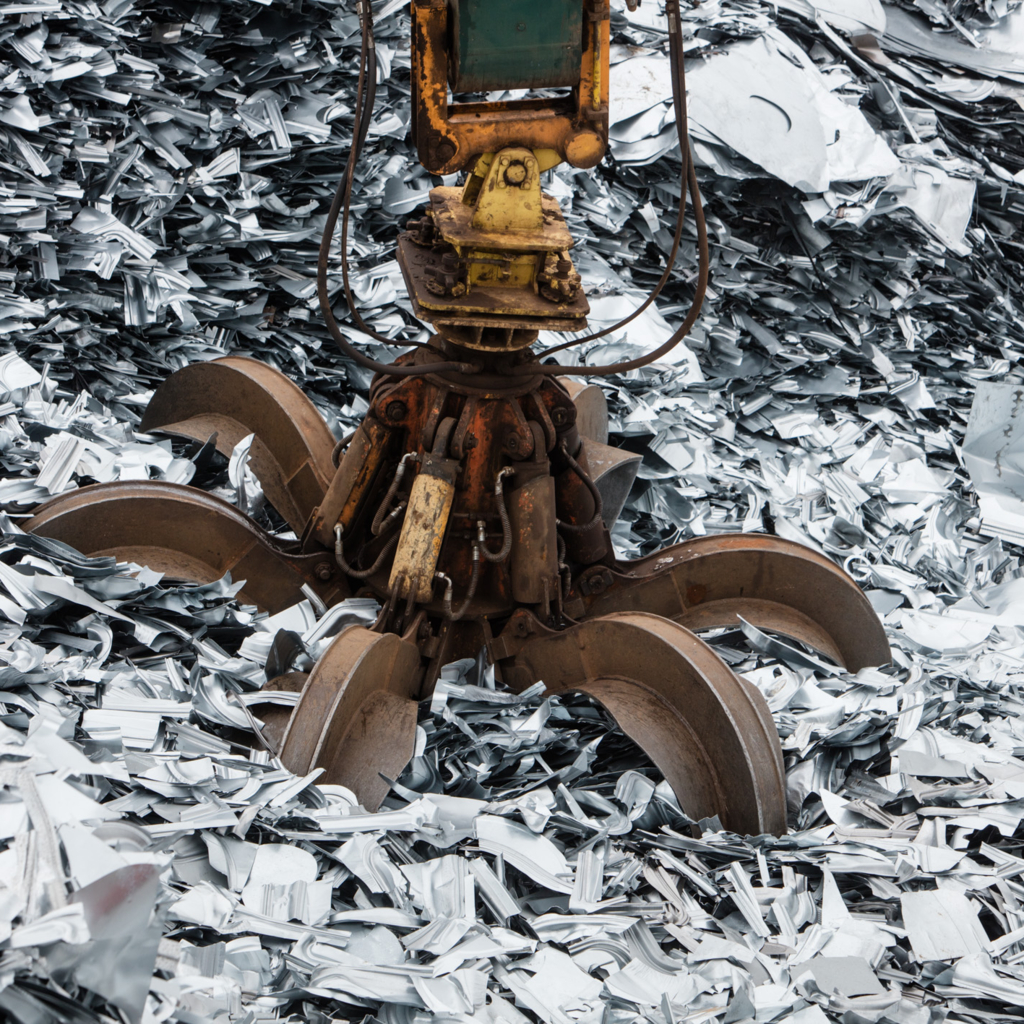 Foto einer Nahaufnahme eines Kran-Greifarms beim Aufnehmen von Recyclingmaterial