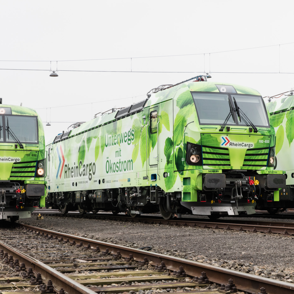 Foto mehrerer RheinCargo Loks mit "Unterwegs mit Ökostrom" Aufdruck